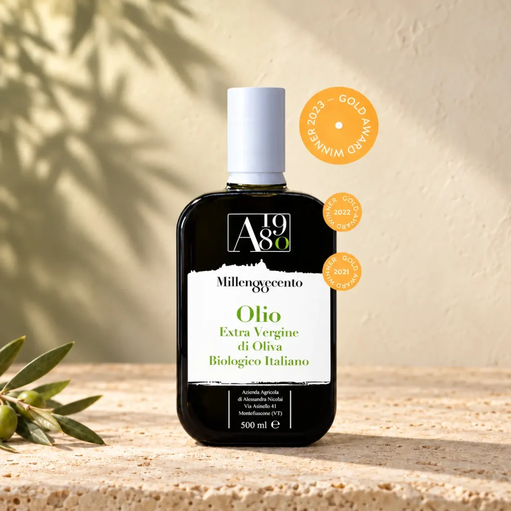 Olio extravergine di oliva biologico Olio80 in bottiglia da 500 ml, su pietra chiara con un ramo d’ulivo